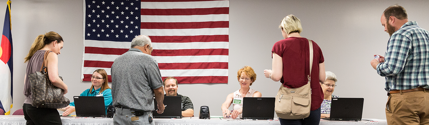 Photo of four voters standing in front of table of four election judges