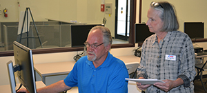 Two people review a computer screen.