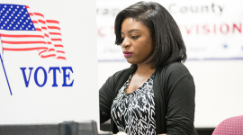 Young African American female sitting at voting booth