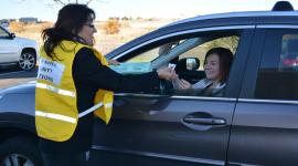 Voter in car delivers ballot to election worker at drive-up drop-off location