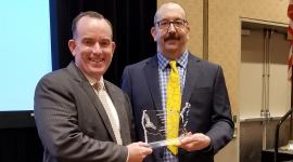 Photo of Clerk and Elections Deputy holding Eagle Award