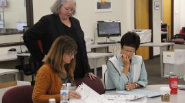 Depurty Dir. of Elections Peg Perl looks on as testing board members inspect test ballots for the 2022 LAT.